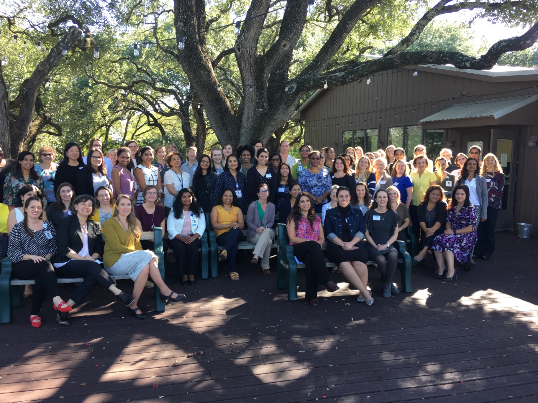 Women physicians gathered under an oak tree